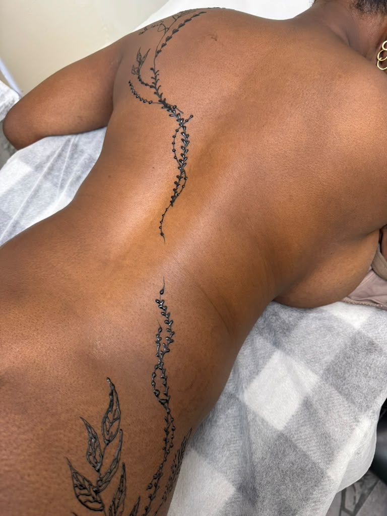Full back spine mehndi with delicate vines, leaves and beadwork — custom henna body art at Magical Waxing Atlanta