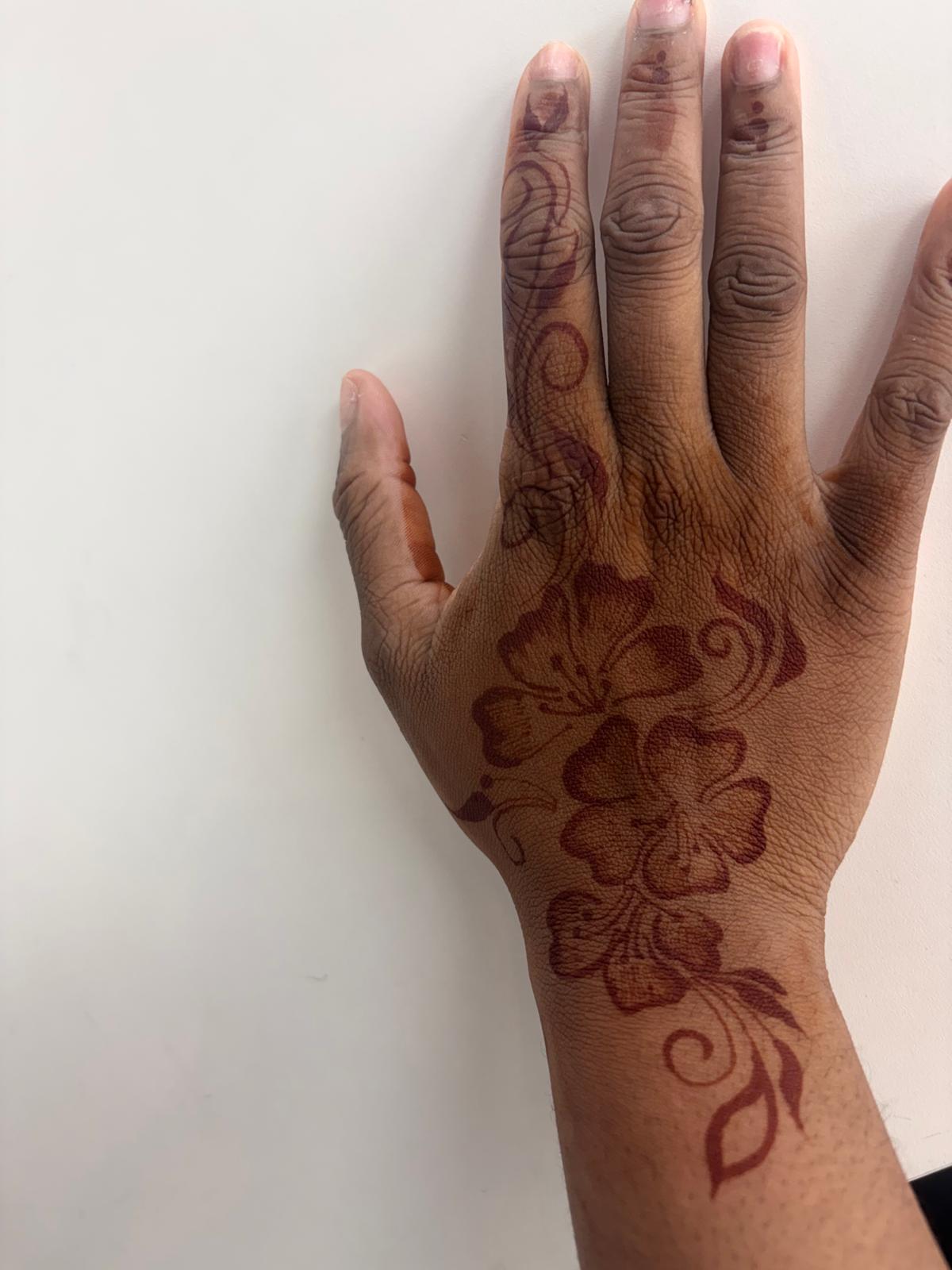 Rich burgundy henna stain of hibiscus hand design after removal — Magical Waxing Atlanta