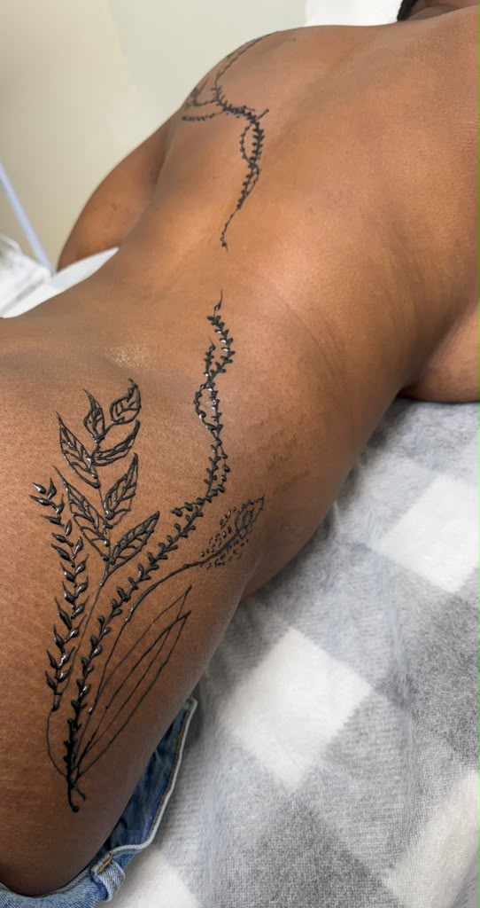 Floral vine and leaf henna design flowing down the spine and lower back — Magical Waxing Atlanta mehndi artist