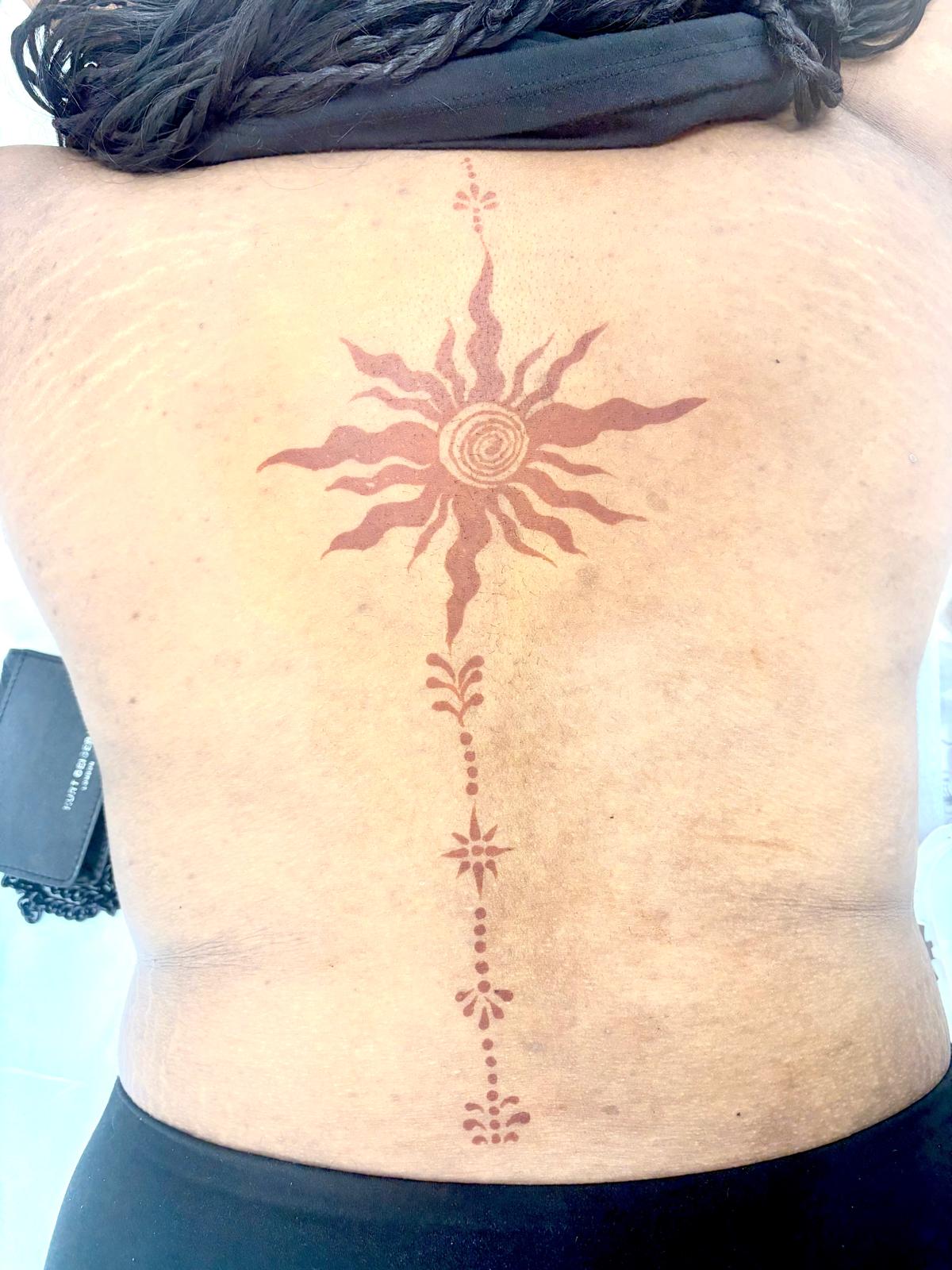 Deep red henna stain of back sun tattoo showing 48-hour result — Magical Waxing Atlanta